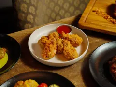 A plate of crisp fried chicken served at a restaurant table